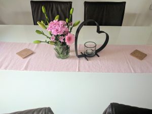 Tischdeko Blumen, rosa Tischläufer und Herz mit Teelicht
